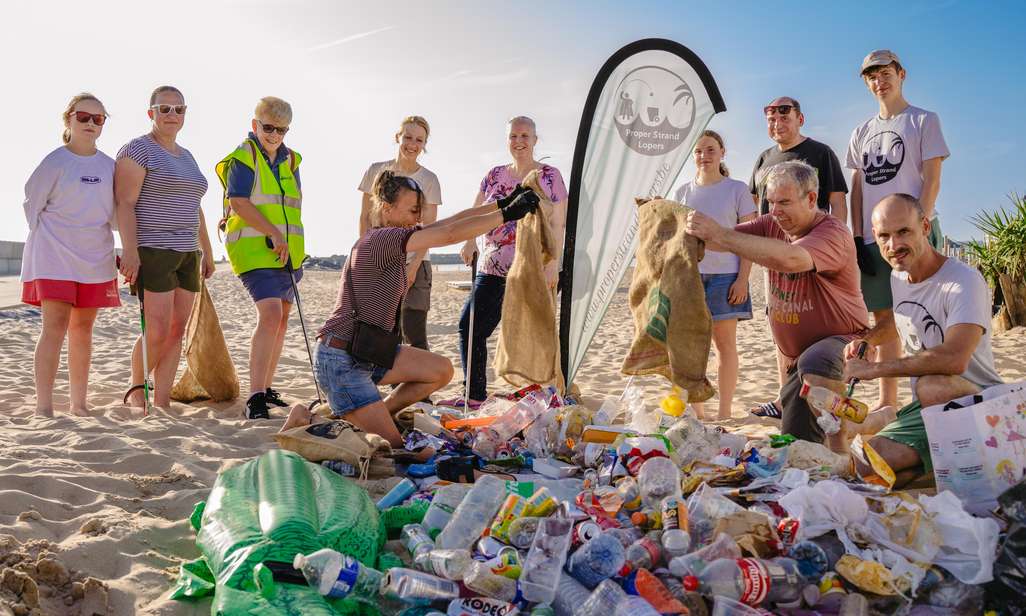 Proper Strand Lopers met berg afval op het strand