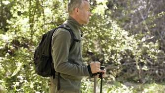 Man met fleece, wandelstokken en rugzak