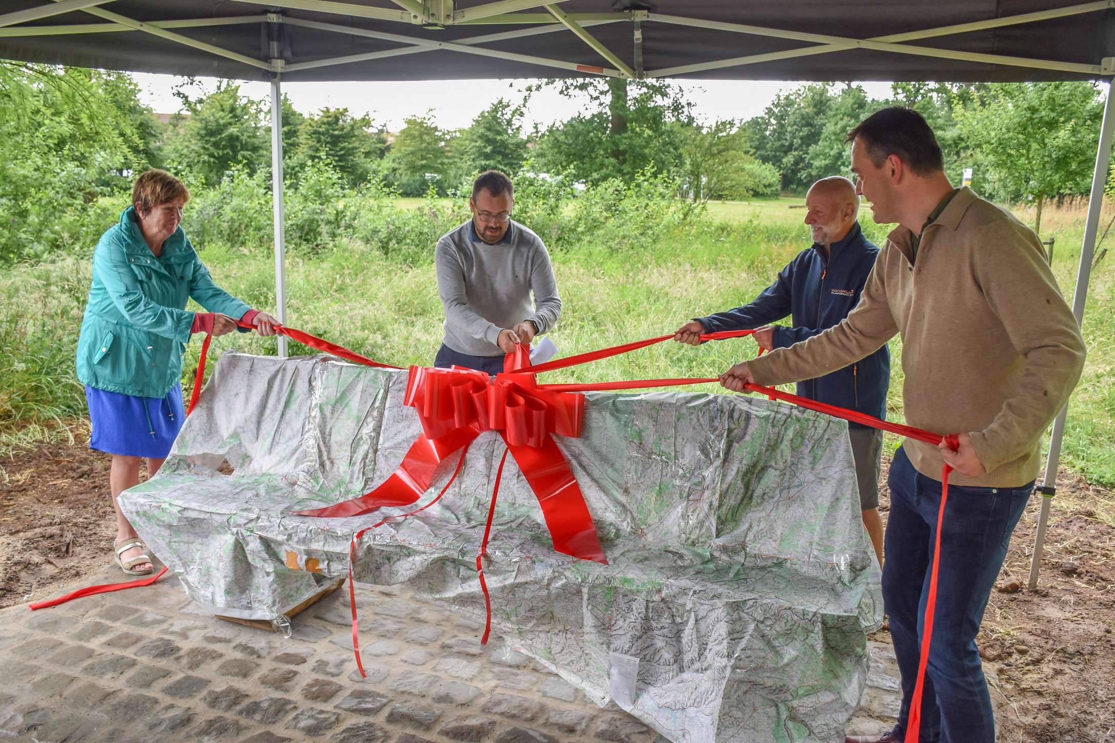 Houten zitbank verpakt in oude wandelkaarten met vier linten, symbool voor de vier verhaallijnen van Zonnebeke